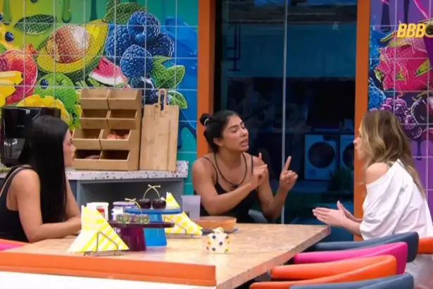 Marciele sentada na cozinha VIP do BBB 26 em frente a Ana Paula Renault gesticulando durante a briga