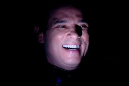 Celso Portiolli no escuro, com o rosto iluminado pela lanterna do celular, após apagão no estúdio do Domingo Legal