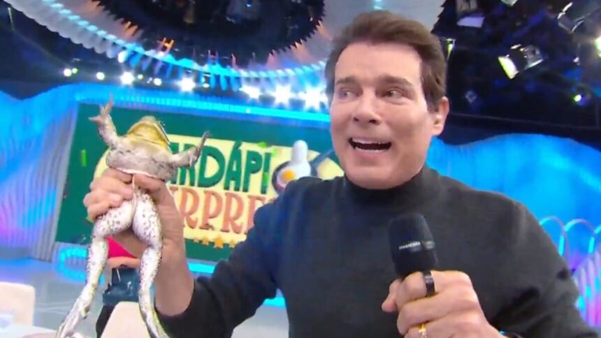 Celso Portiolli segurando uma perereca na mão ao vivo no Domingão Legal