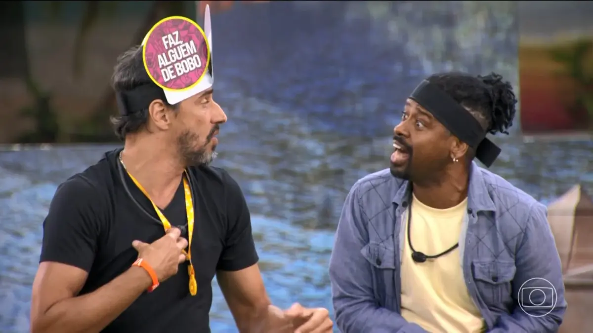 Alberto Cowboy com placas na cabeça discute com Leandro Boneco na área externa do BBB 26 durante o sincerão