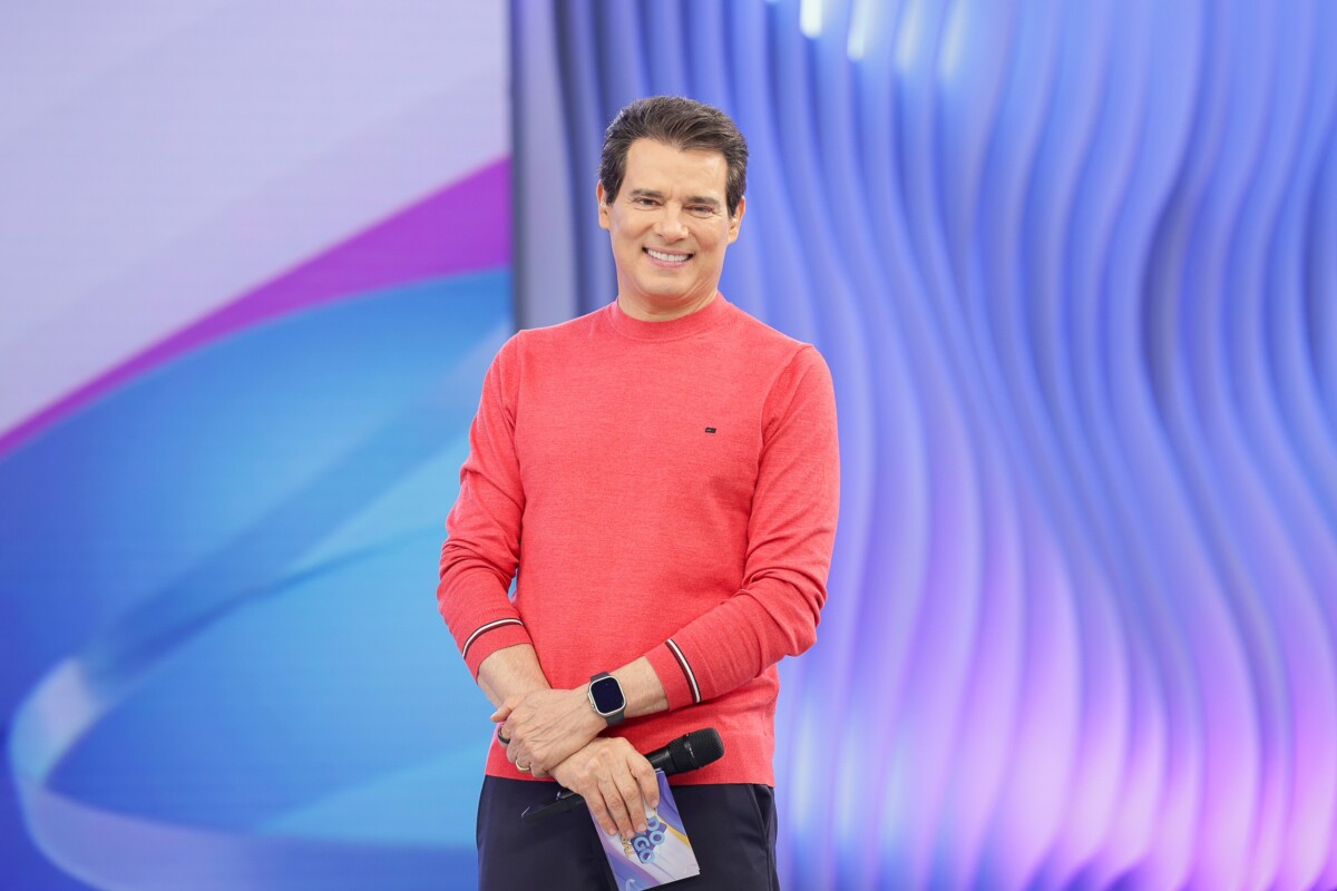 Celso Portiolli sorridente no cenário do Domingo Legal