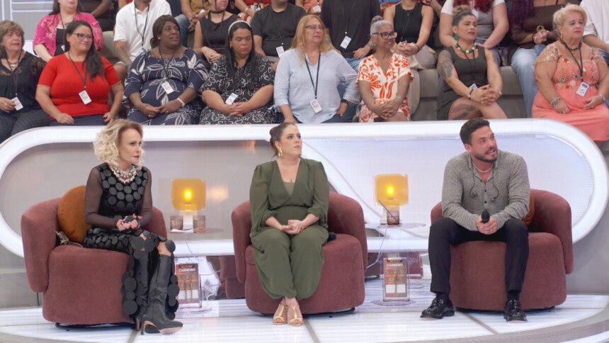 Ana Maria Braga, Tati Machado e Wesley Safadão sentados nas poltronas do cenário do programa de Em Família com Eliana olhando para a apresnetadora