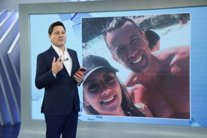 Eleandro Passaia em frente ao telão do Balanço Geral que mostra coronel Neto ao lado de sua esposa em foto antiga