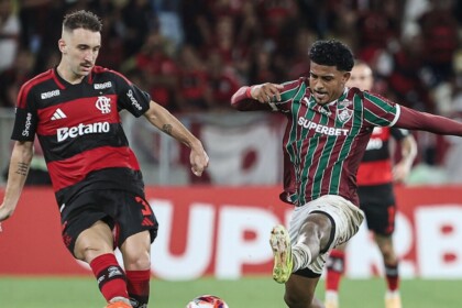 Jogadores de Flamengo e Fluminense em campo, jogo do Carioca, com transmissão da Globo