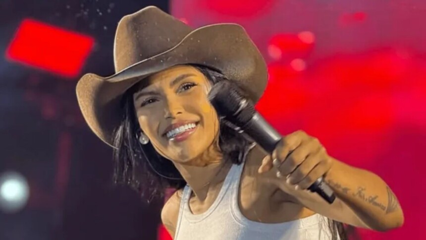 Flay sorrindo, em trecho de show com chapéu no cabeça