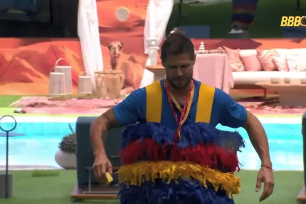 Jonas caminha pelo gramado da área externa do BBB 26 vestido como esponja no Monstro do BBB 26
