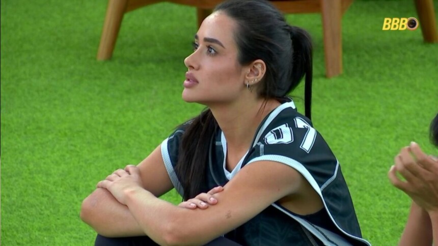 Jordana de colete da Prova do Líder, sentada no jardim, na casa do BBB 26
