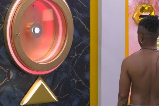 Leandro encarando o Botão de Desistência, que está vermelho, no BBB 26