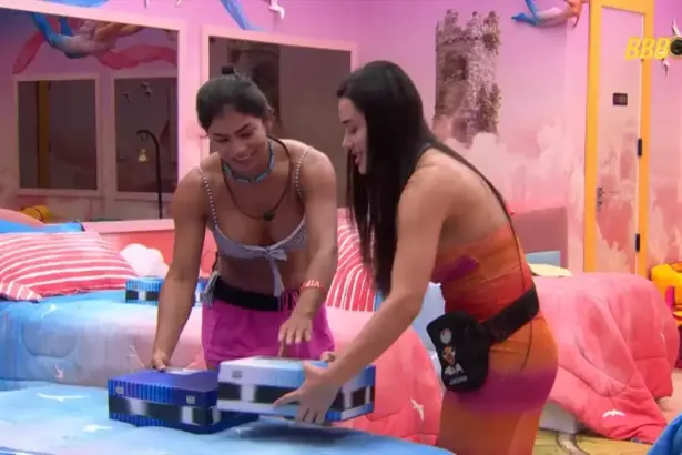 Marciele sorrir ao lado de Jordana olhando as caixas da Máquina do Poder no quarto do BBB 26
