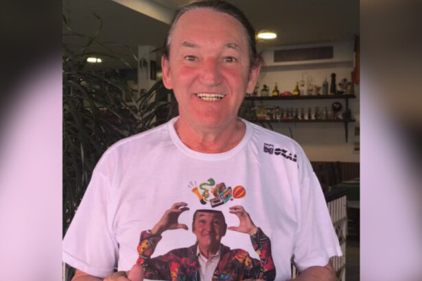 Marquito sorridente vestindo a camisa com seu rosto estampado