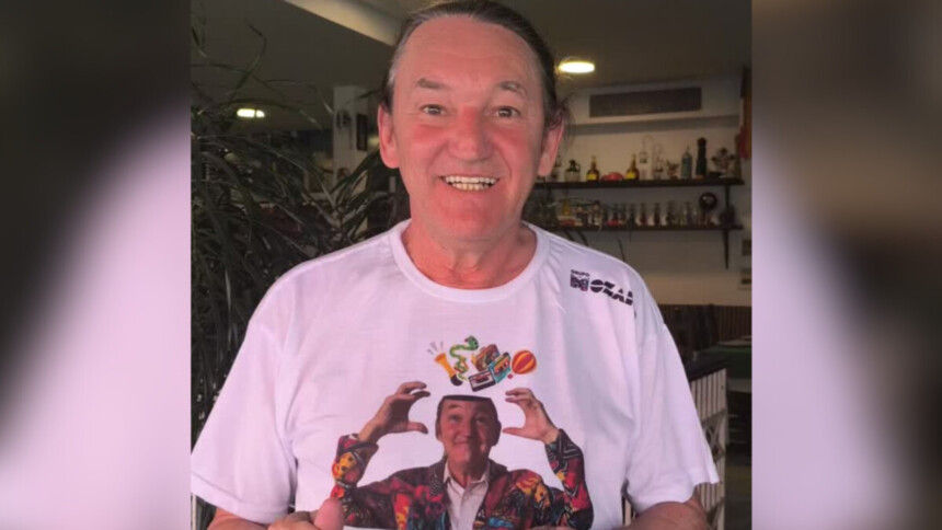 Marquito sorridente vestindo a camisa com seu rosto estampado