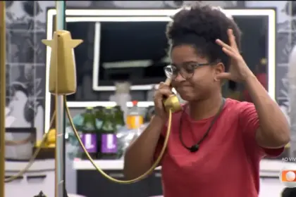 Milena atendeu o Bg Fone dourado da cozinha do BBB 26 e levanta um braço assustada
