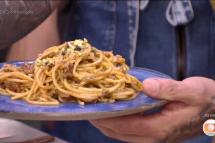 Diogo Nogueira segura o prato azul com Espaguete com ragu de linguiça e pesto de pistache no programa É de Casa