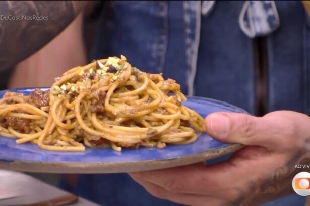 Diogo Nogueira segura o prato azul com Espaguete com ragu de linguiça e pesto de pistache no programa É de Casa