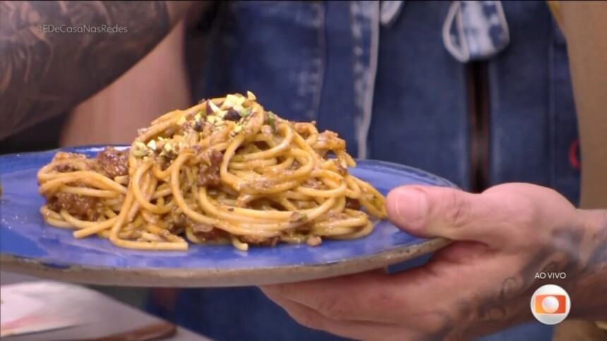Diogo Nogueira segura o prato azul com Espaguete com ragu de linguiça e pesto de pistache no programa É de Casa