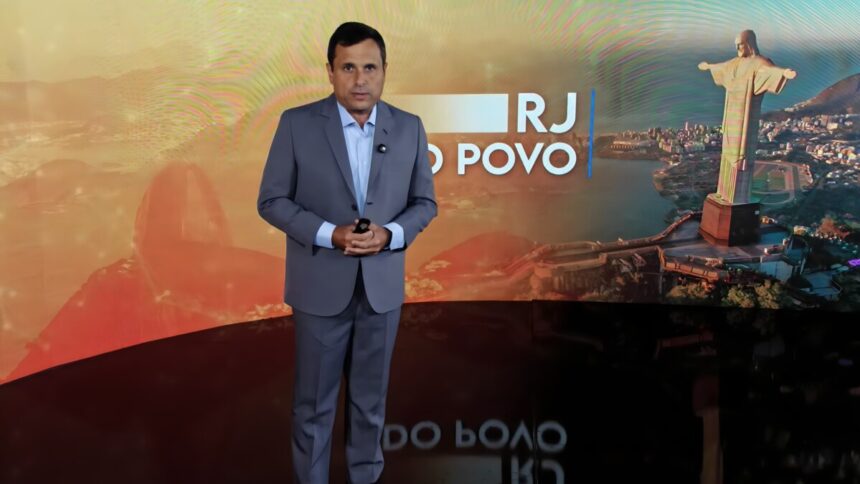 Fabio Barretto de terno cinza na frente do telão cenário do RJ do Povo na RedeTV!