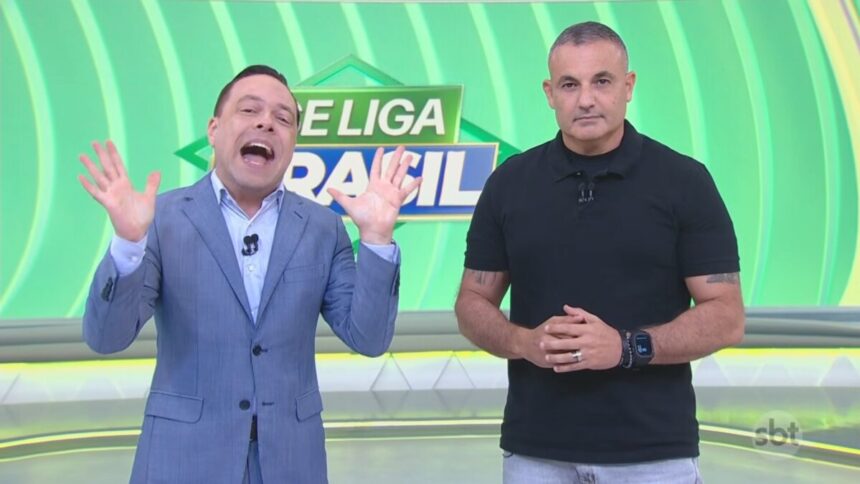 Thiago Gardinalli levanta as mãos para o alto e abre a boca comemorando a audiência ao lado do Delegado Palumbo no cenário do Se Liga Brasil