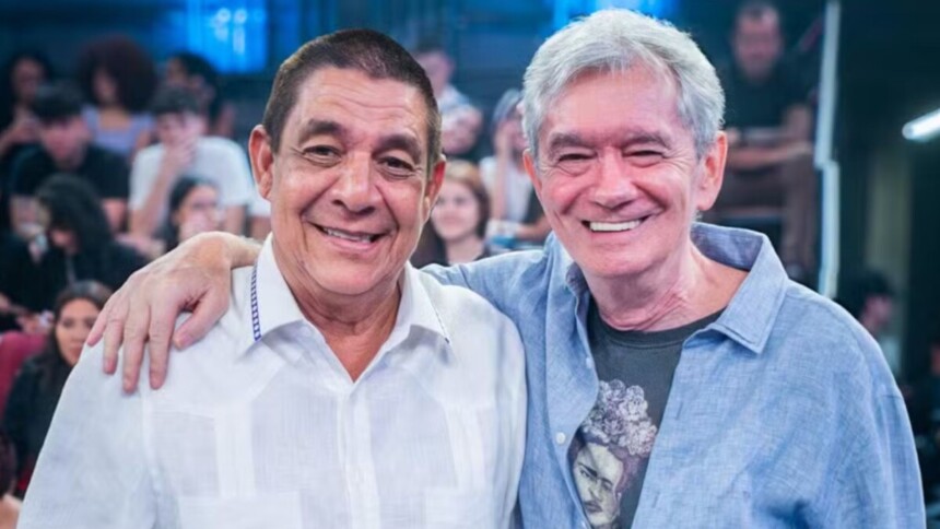 Serginho Groisman e Zeca Pagodinho abraçados e sorrindo no palco do Altas Horas