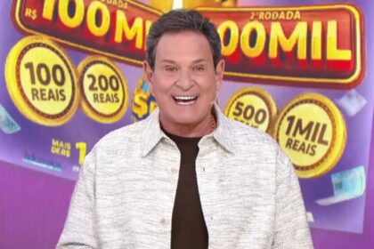 Luis Ricardo sorridente em frente ao telão com o bilhete lilás da Tele Sena Semanal edição 97