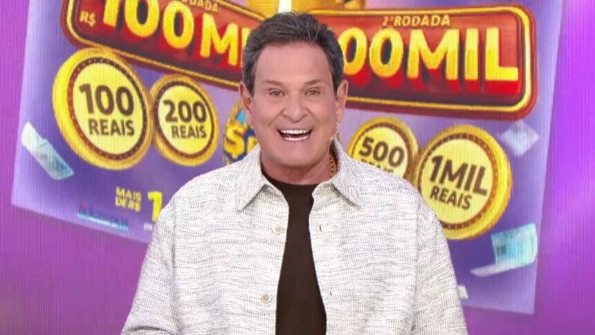 Luis Ricardo sorridente em frente ao telão com o bilhete lilás da Tele Sena Semanal edição 97