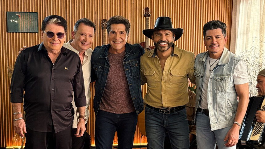 Gilberto & Gilmar, Daniel e Zé Henrique & Gabriel na sala do estúdio do programa Viver Sertanejo. Todos estão abraçados e em pé sorridentes