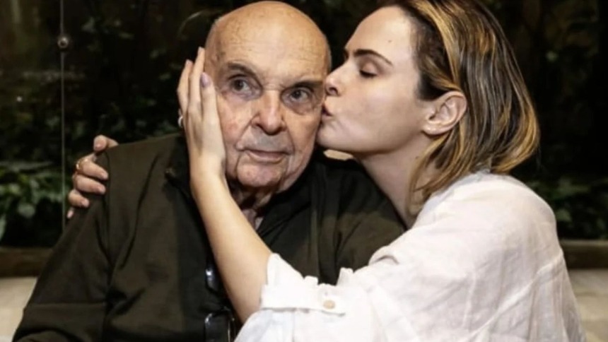 Ana Paula Renault dando um beijo no rosto do pai, já idoso, em foto posada