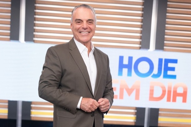 Dr. Antônio Sproesser sorridente e em pé no cenário do programa Hoje em Dia