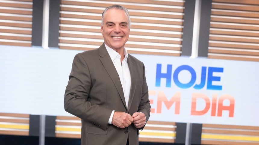 Dr. Antônio Sproesser sorridente e em pé no cenário do programa Hoje em Dia