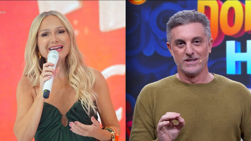 Eliana segura microfone branco no cenário do Em Família com Eliana dividindo tela com Luciano Huck no Domingão