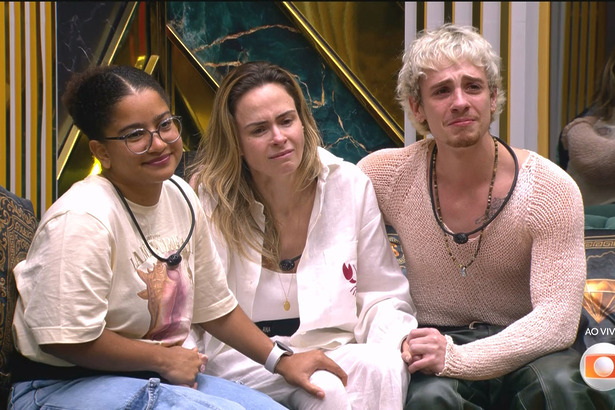 Milena, Ana Paula Renault e Juliano Floss sentados no sofá do BBB 26, chorando emocionados