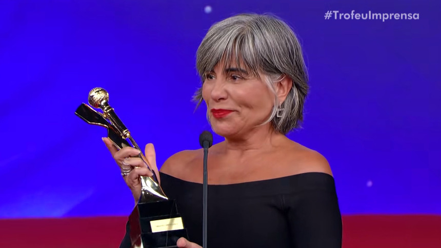 Gloria Pires segurando a estatueta, em trecho de homenagem no Troféu Imprensa