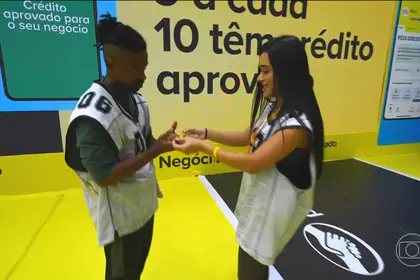 Jordana entrega pulseira para Leandro Boneco que olha para ela assustado no cenário da Prova do Líder do BBB 26