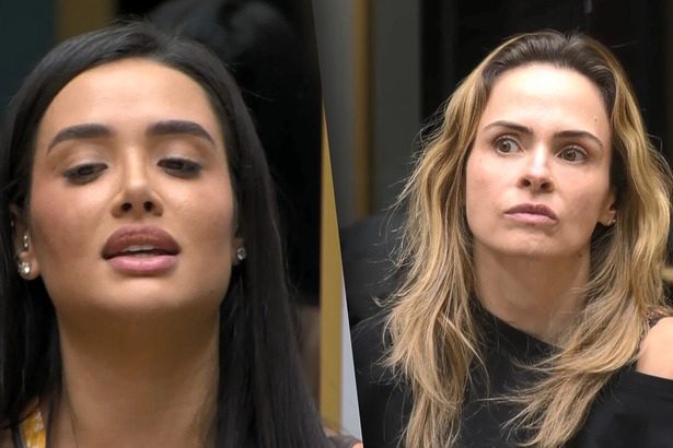 Jordana divide tela com Ana Paula Renault. As duas estão sentadas no sofá da sala do BBB 26. Jordana com a boca aberta indica Ana Paula que segue séria