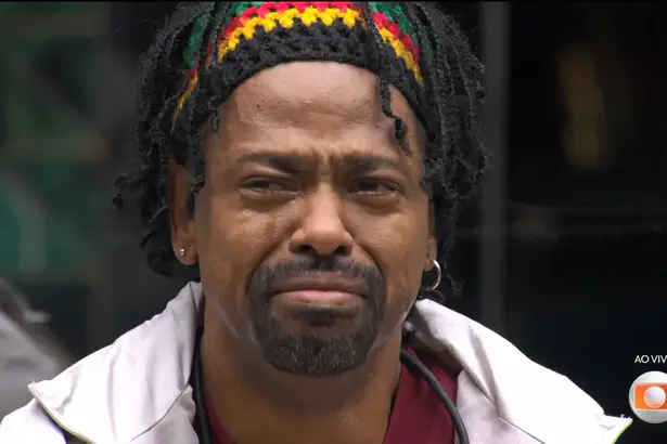 LEandro Boneco chorando copiosamente com lágrimas nos olhos sentado no sofá do BBB 26