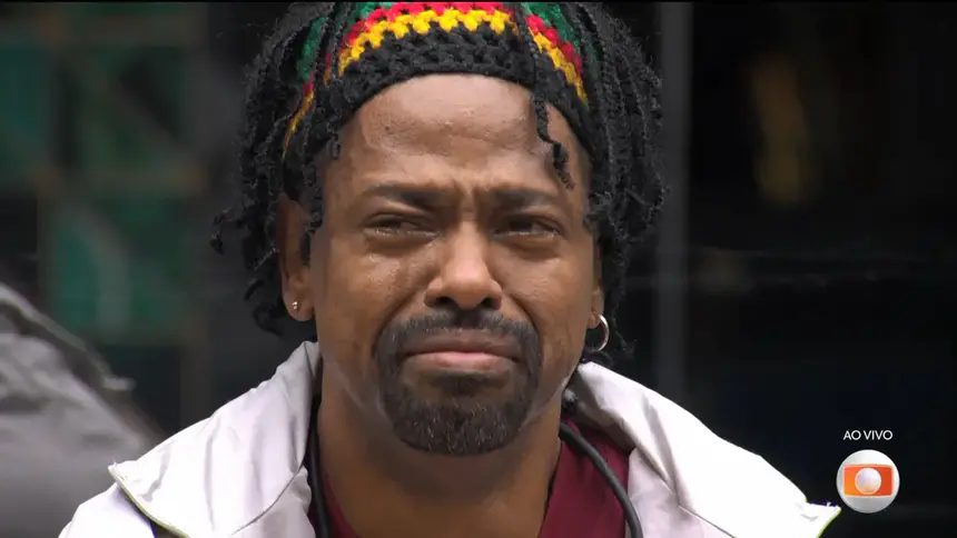 LEandro Boneco chorando copiosamente com lágrimas nos olhos sentado no sofá do BBB 26