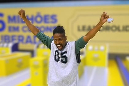 Leandro Boneco com a boca aberta e os braços levantados gritando de felicidade no cenário da última Prova do Líder do BBB 26