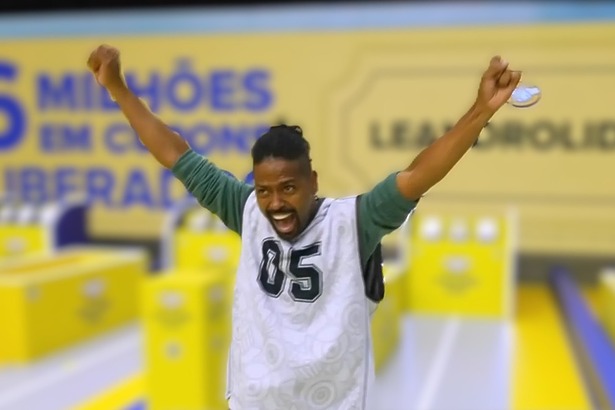 Leandro Boneco com a boca aberta e os braços levantados gritando de felicidade no cenário da última Prova do Líder do BBB 26