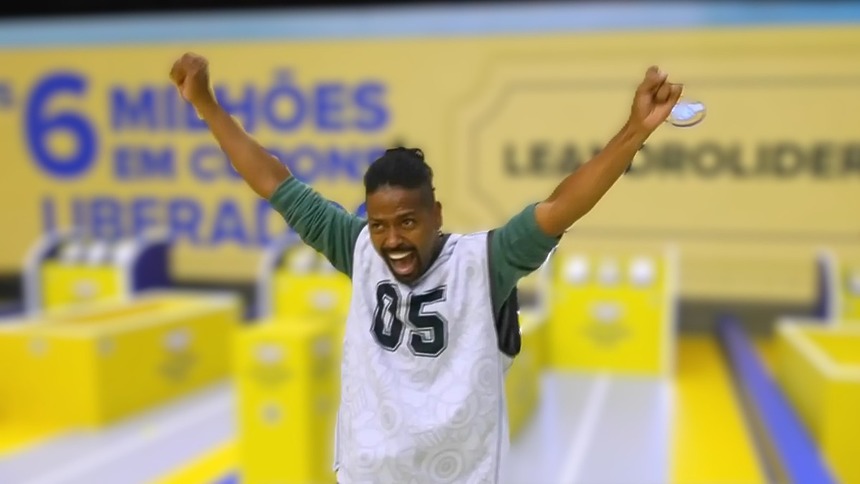 Leandro Boneco com a boca aberta e os braços levantados gritando de felicidade no cenário da última Prova do Líder do BBB 26