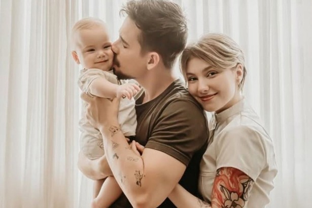 Lucas Borbas e Isabel Veloso, com o filho colo, sorrindo em momento de família