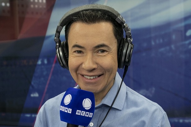 Lucas Pereira com o microfone em mãos, nos bastidores da transmissão do Paulistão Feminino na Record News