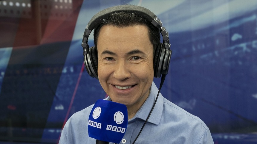 Lucas Pereira com o microfone em mãos, nos bastidores da transmissão do Paulistão Feminino na Record News