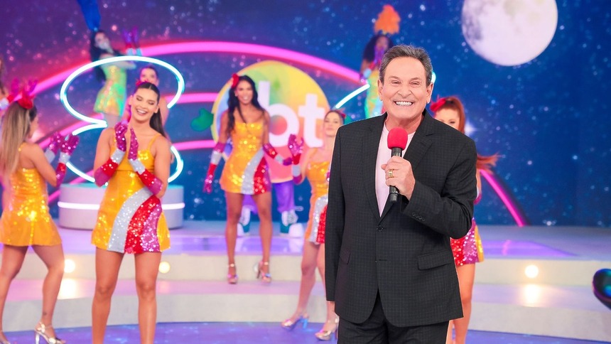 Luis Ricardo sorridente no cenário do Viva a Noite