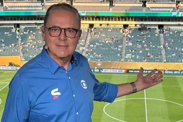 Luis Roberto apontando para um estádio no fundo