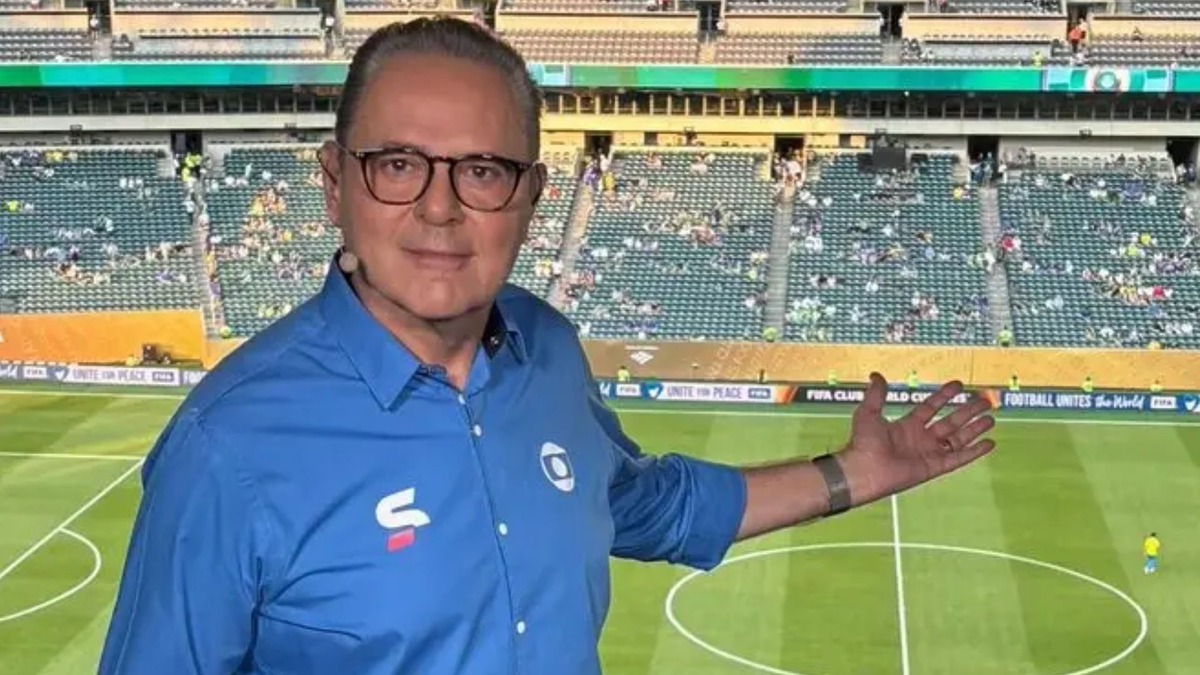 Luis Roberto apontando para um estádio no fundo