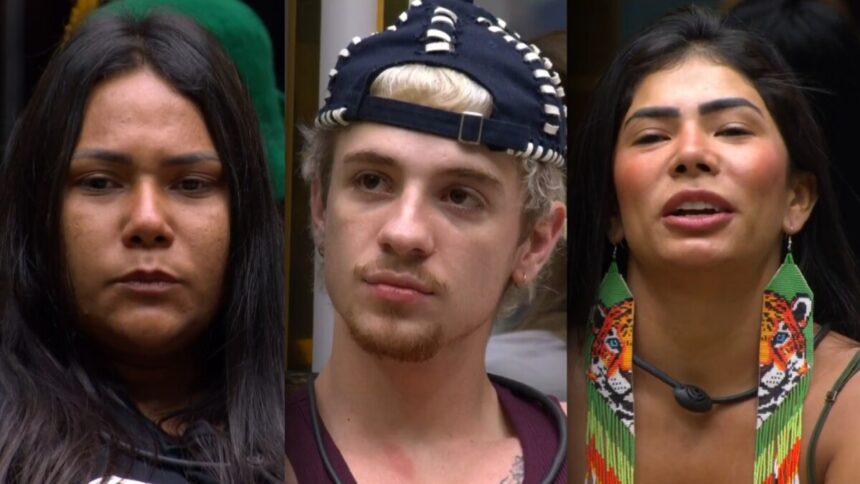 Chaiany, Juliano e Marciele, com expressões sérias, sentam-se no sofá do BBB 26 após descobrirem que estão no 13º Paredão
