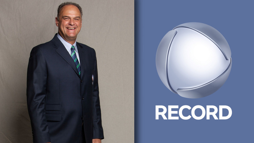 Oscar Schmidt sorridente em pé no estúdio de divulgação do esporte da RECORD. Em montagem ele divide tela com o logo atual da emissora