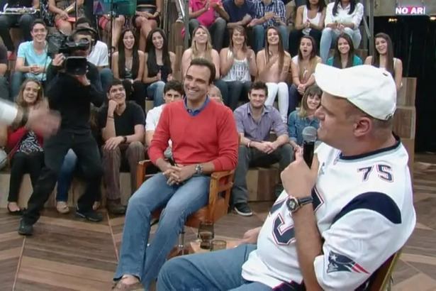 Tadeu Schmidt sorrir ao lado de Oscar Schmidt no palco do Altas Horas