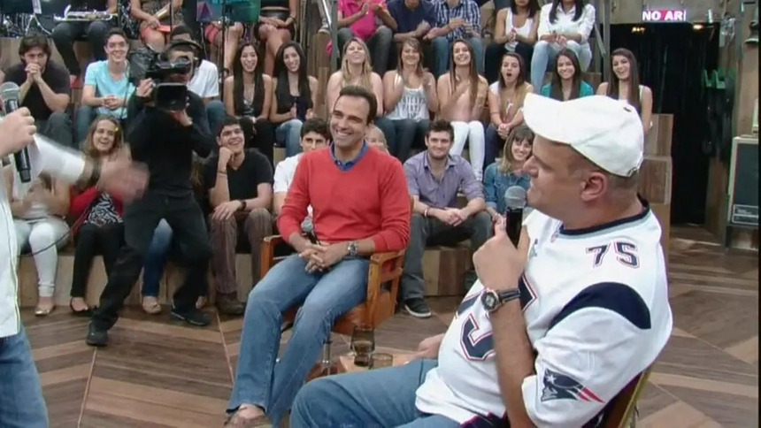 Tadeu Schmidt sorrir ao lado de Oscar Schmidt no palco do Altas Horas