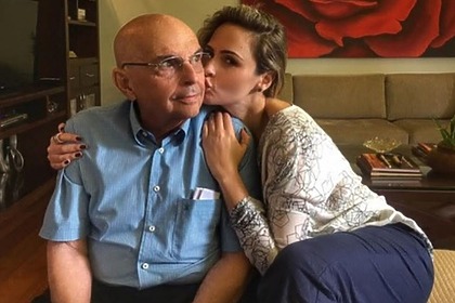 Ana Paula Renault dando um beijo no rosto do pai, já idoso, em foto posada