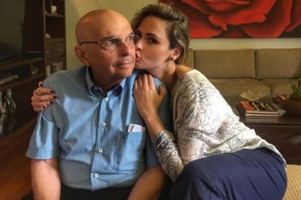 Ana Paula Renault dando um beijo no rosto do pai, já idoso, em foto posada